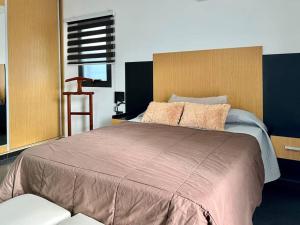 Un dormitorio con una cama grande con cabecero de madera. en Cambacuá Santa Ana!, en Villa María
