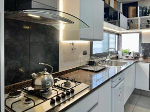 a kitchen with a stove with a tea kettle on it at Cambacuá Santa Ana! in Villa María
