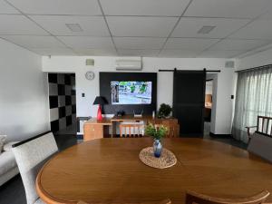 Una sala de estar con una mesa y un televisor. en Cambacuá Santa Ana!, en Villa María