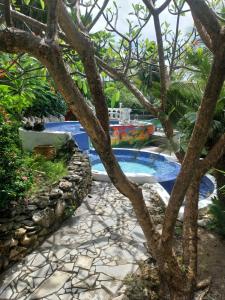 una piscina con un árbol en el primer plano en Le grand palm gîte filao en Les Basses