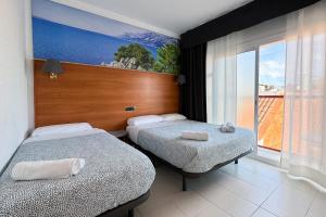 Habitación de hotel con 2 camas y ventana grande. en Hotel Maremagnum, en Lloret de Mar