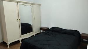 ein Schlafzimmer mit einem Bett und eine Kommode mit einem Spiegel in der Unterkunft La Elvira in San Antonio de Areco