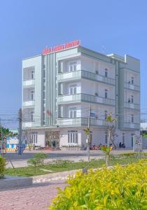a white building with a red sign on it at Khách Sạn Hải Long Đảo Phú Quý in Cu Lao Thu