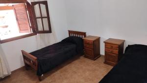 a bedroom with two beds and a dresser and a window at La Elvira in San Antonio de Areco