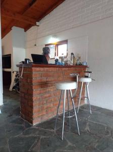 mężczyzna siedzący w barze z laptopem w obiekcie Casa Arrayan - Entorno único 20 metros del lago w mieście Bariloche