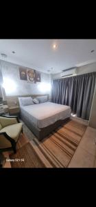 a bedroom with a large bed and a window at The Signature Hotel Apartment Accra Ghana in Accra