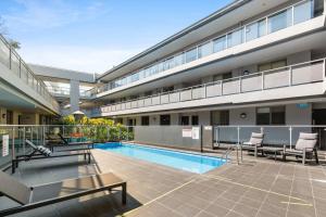 a building with a swimming pool in front of a building at Spacious 1-Bed with Pool & Gym 5 Minutes from CBD in Sydney
