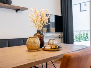drewniany stół z wazonem i świecą w obiekcie Falken Suites TOP 2 w Kaprunie
