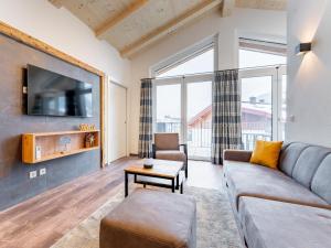 a living room with a couch and a tv at Falken Suites TOP 8 in Kaprun