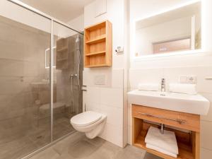 La salle de bains est pourvue de toilettes, d'un lavabo et d'une douche. dans l'établissement Falken Suites TOP 8, à Kaprun