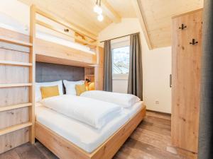a bedroom with a bunk bed and a window at Falken Suites TOP 8 in Kaprun
