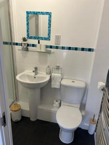 La salle de bains est pourvue de toilettes blanches et d'un lavabo. dans l'établissement Long Stay - Free Parking - Contractors - Train Station - Students, à Colchester
