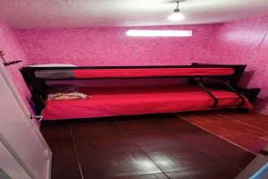 1 dormitorio con cama roja en una pared de color rosa en Casa campestre familiar con alberca y areas recreativas, en Totolapan