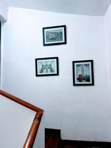a staircase with three pictures on a white wall at La Casa de Agos in La Rioja