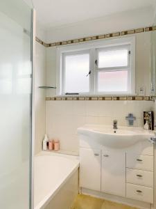 a white bathroom with a sink and a shower at Home in central Auckland in Auckland