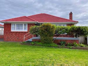 a red brick house with a red roof at Home in central Auckland in Auckland