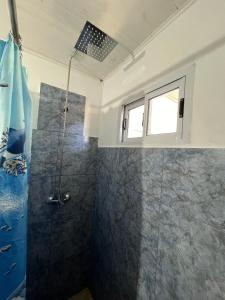 a bathroom with a shower and a window at Departamentos Avellaneda in Carhué