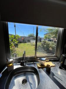 fregadero de cocina y ventana con vistas a un campo en Departamentos Avellaneda en Carhué