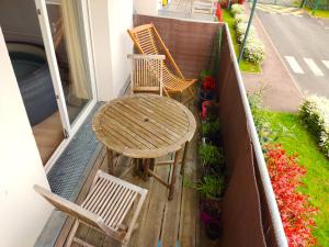 a wooden table and two chairs on a balcony at Le nid de l'Almont jacuzzi privatif, private jacuzzi Hot Tub near Olympic Games MELUN in Melun