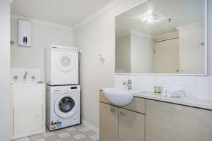 y baño con lavadora y lavamanos. en Convenient 2-Bed Apartment in the Heart of Perth en Perth