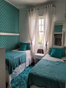 - une chambre avec 2 lits et une fenêtre dans l'établissement Apartamento pé na areia, à São Vicente