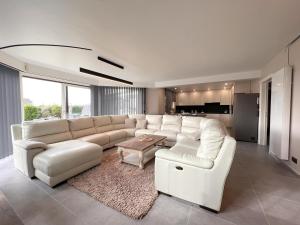 ein Wohnzimmer mit einem weißen Sofa und einem Tisch in der Unterkunft De Golfbreker in Middelkerke