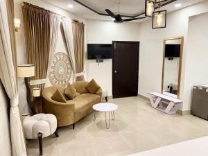 a living room with a couch and a table at Capital Lodges in Islamabad
