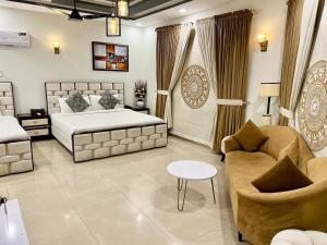 a bedroom with a bed and a couch and a table at Capital Lodges in Islamabad