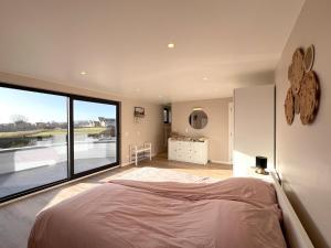 ein Schlafzimmer mit einem großen Bett und einem großen Fenster in der Unterkunft De Golfbreker in Middelkerke