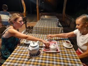 duas mulheres em pé numa mesa com panelas de chá em Morakanda Eco Villa em Elpitiya