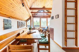 a dining room with wooden tables and chairs at Holiday Home Bela in Bohinjska Bela