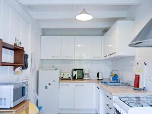 a kitchen with white cabinets and a white refrigerator at Gite Le Chevalier in Sourdeval-les-Bois