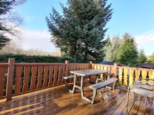 a wooden deck with a table and chairs on it at Serene Snowdonia Retreat in Trawsfynydd