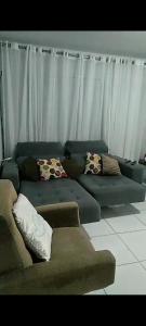 ein Wohnzimmer mit einem Sofa mit Kissen darauf in der Unterkunft Flat Sandra in Teixeira de Freitas