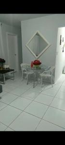 a dining room with a glass table and two chairs at Flat Sandra in Teixeira de Freitas