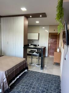 Habitación con cama y cocina con escritorio. en Flat Moderno Ilha Bela en Alter do Chao