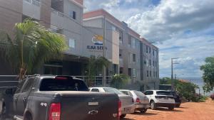 rząd samochodów zaparkowanych przed budynkiem w obiekcie Flat Moderno Ilha Bela w mieście Alter do Chao