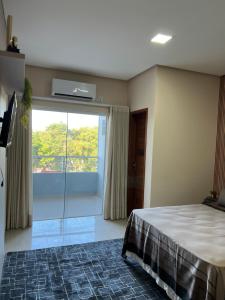una camera con un letto e una grande finestra di Flat Moderno Ilha Bela ad Alter do Chão