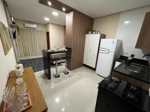Flat Moderno Ilha Bela في ألتر دو تشاو: مطبخ مع ثلاجة بيضاء وطاولة