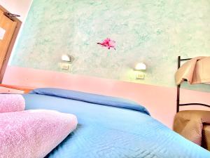ein Schlafzimmer mit einem Bett und einem Drachen an der Wand in der Unterkunft Hotel Majorca Nuova Gestione Rimini 100 m dalla spiaggia in Rimini