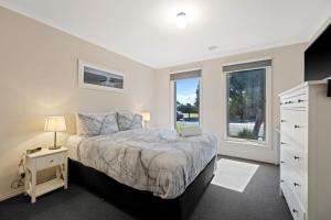a bedroom with a large bed and a window at Shoalhaven Escape Cowes in Cowes