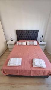 sypialnia z dużym łóżkiem i 2 białymi ręcznikami w obiekcie Hermoso departamento 4 personas w BuenosAires