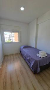 1 dormitorio con cama y ventana en Hermoso departamento 4 personas en Buenos Aires