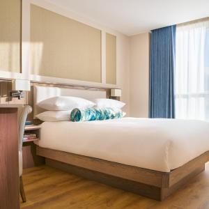 een slaapkamer met een groot bed met witte lakens en kussens bij The James Hotel in Tralee