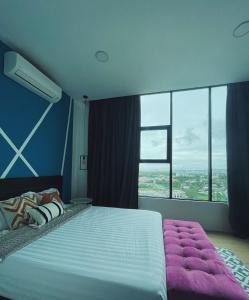 een slaapkamer met een groot bed en een groot raam bij Pleasant Amenities at ITCC Manhattan Suites in Penampang