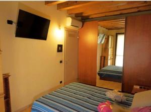 a bedroom with a bed and a flat screen tv at La casa dell'ulivo in Brembate