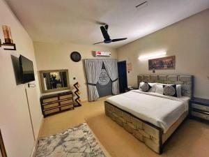 a bedroom with a bed and a ceiling fan at Capital Lodges in Islamabad