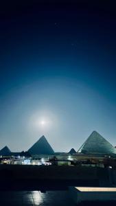 a view of the pyramids of giza at night at Locanda Pyramids Hotel in Cairo