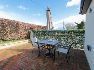 a table and chairs with an umbrella on a patio at Little Haven in Blandford Forum