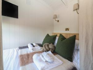 a bedroom with a bed with towels on it at Shepherd Hut 2 in Harrogate